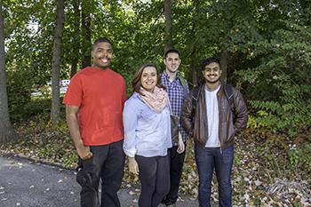 four students standing together outdoors