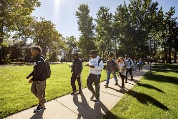 students walking on sunny campus pathway