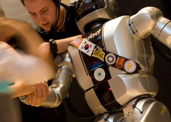 student interacting with a humanoid robot