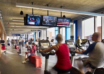 people exercising on treadmills in a gym