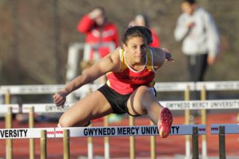 athlete jumping hurdles with gwynedd mercy university text