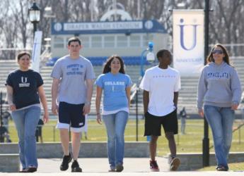 students walking on campus with 'U' sign