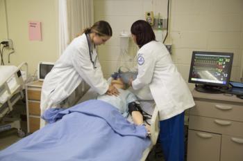 nursing simulation lab with students and dummy