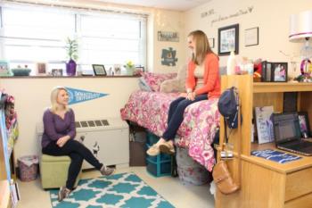 dorm room with students and decor