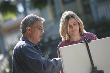 teacher and student reviewing drawings outdoors