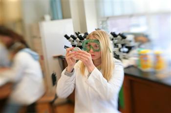 student considering a vial in a lab