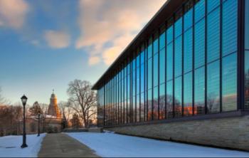 glass building reflecting sky at sunset