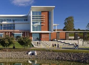 modern campus building with pond and students