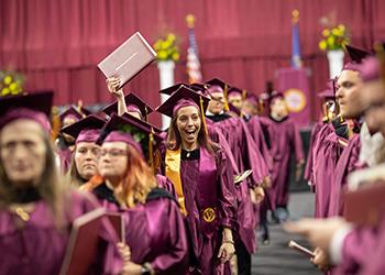 graduates in purple gowns at ceremony