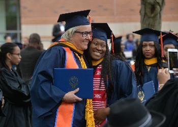 graduates smiling with diplomas