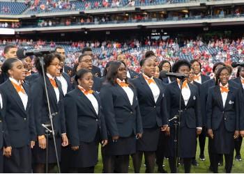 choir performing at a sports field