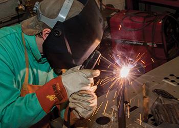 person welding with protective gear