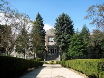 front view of a brick building with greenery