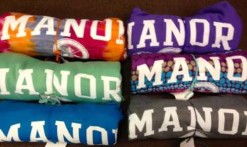 folded shirts with 'manor' text in various colors