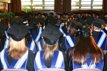 graduates in blue and black robes at ceremony