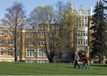 two students walking by traditional campus building