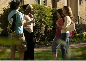 students conversing near academic buildings