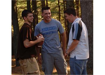 three students chatting in a wooded area