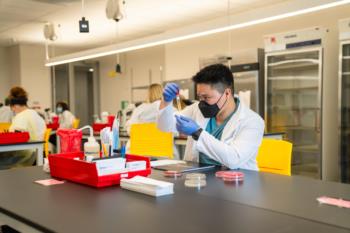 student in a lab coat conducting a science experiment