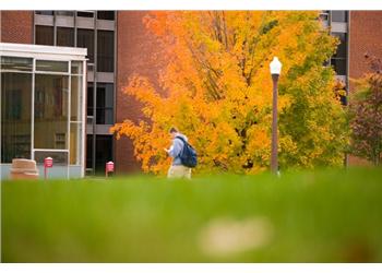 student walking past autumn trees