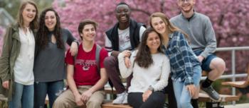 group of students smiling with cherry blossoms