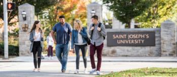 students walking by 'saint joseph's university' sign