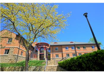 brick building with a circular structure and trees