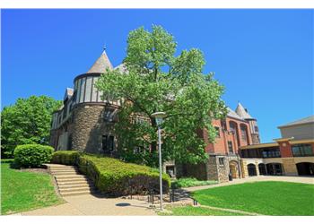 old stone building with a turret and blue sky