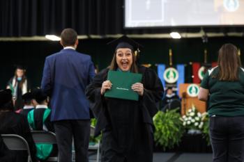 graduate holding diploma, cheering