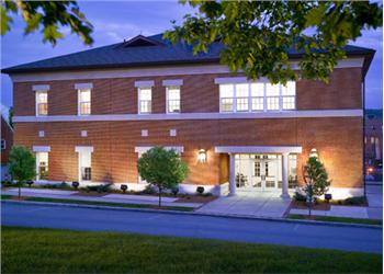 two-story building with illuminated entrance at dusk