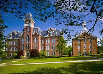 brick building with clock tower behind green lawn