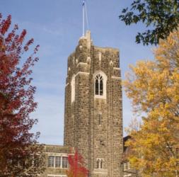 stone tower on a college campus with autumn trees