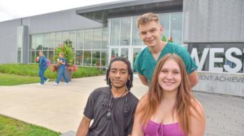 three diverse students outside building