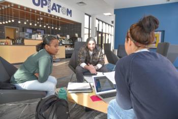 three students studying together near cafe