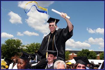 graduate raising his diploma in celebration