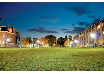 twilight view of campus buildings and lit pathways