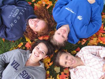 friends lying on grass with autumn leaves