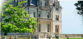 castle-like university building with green lawn