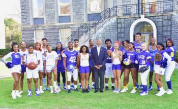 group photo with athletes, cheerleaders and official