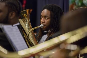 french horn player performing with symphonic band