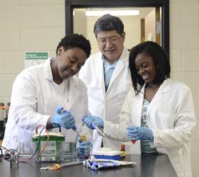 students conducting an experiment with a professor