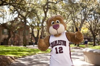 mascot posing on campus with thumbs up