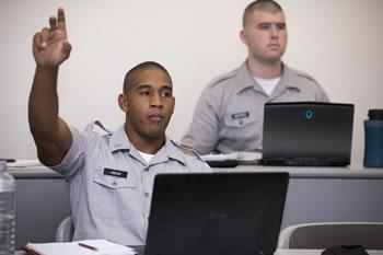 student raising hand in a classroom setting