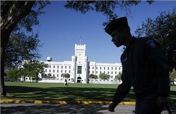 silhouette of a person walking past a historic building