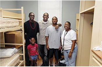 family posing in a dorm room with bunk beds