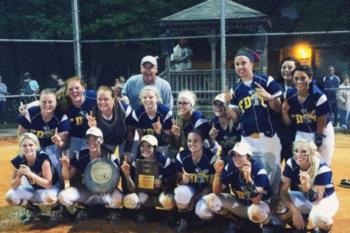 softball team posing with trophy at night