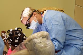 dental student practices on patient with instructor