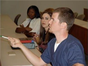 student pointing in a classroom setting