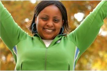 smiling woman in a green jacket outdoors