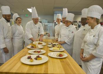 culinary students inspect dishes with instructor